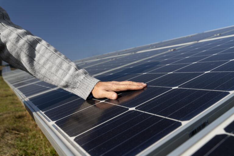 Main posé sur un panneau solaire