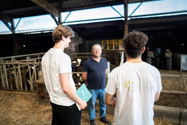 Deux membres de l'équipe discutent avec un agriculteur de son projet dans son exploitation